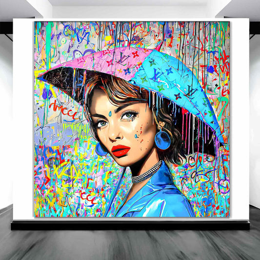 Art gallery display of Audrey Hepburn holding an umbrella decorated with graffiti and Louis Vuitton-inspired monogram and a backdrop with patterns of graffiti and dripping paint. Painted Rainfall-Graphique Addictions.